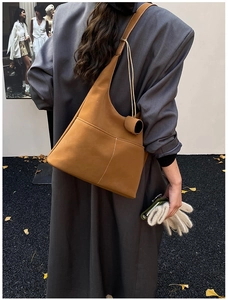 Macro shot of brown suede hobo bag detailing white contrast stitching and soft matte texture