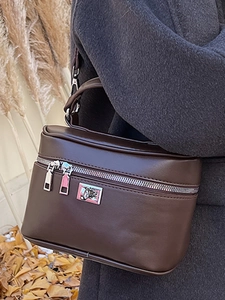 Minimalist dark brown box bag with dual silver zippers and adjustable shoulder strap