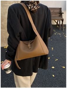 Détail d'un sac cabas en cuir marron à motif litchi porté par un mannequin en automne