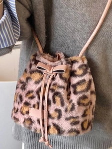 Pink leopard print faux fur bucket bag with drawstring closure and leather bow detail