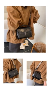 Detail of black PU shoulder bag with silver rotary buckle and contrast stitching