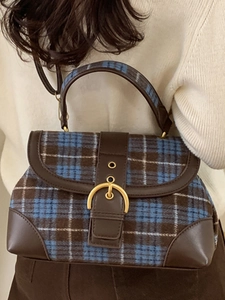 Vintage crossbody saddle bag with blue plaid fabric and leather strap on model