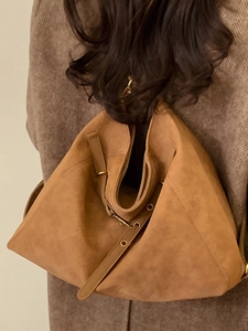 Brown woven leather backpack styled on a brown tweed coat for a vintage winter aesthetic