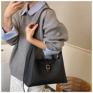 Détail du sac bandoulière en cuir grainé noir avec une boucle carrée en métal doré