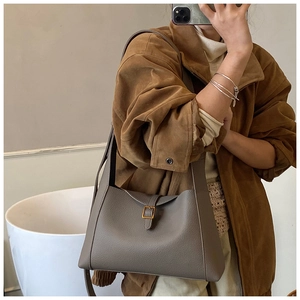 Détail d'un sac sous les aisselles gris vintage avec texture litchi et boucle dorée sur veste