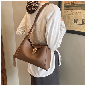 Détail d'un sac à bandoulière en cuir marron foncé avec motif litchi et boucle en métal