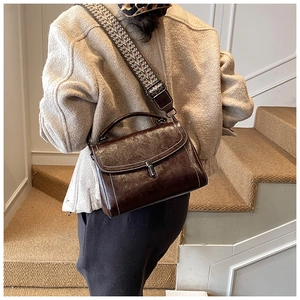 Detailed view of vintage dark brown leather crossbody bag with ethnic woven strap