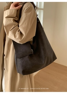 Detail of large brown tote bag with leather texture and matching small zipper pouch