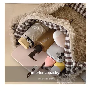 Detail of the spacious interior of the beige fleece tote bag with a plaid lining