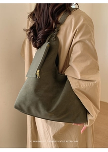 Close-up of minimalist olive green hobo bag featuring polished metal zipper detail