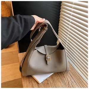 Détail de la texture cuir grainé taupe et du fermoir doré sur ce sac fourre-tout chic
