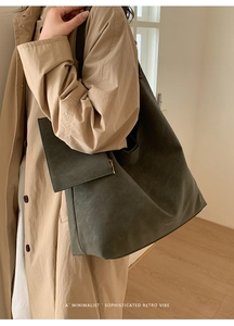 Close-up of olive green leather tote bag with matching zipper pouch for daily commute