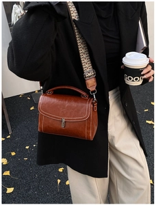 Brown vintage leather shoulder bag with wide woven strap and contrast stitching detail