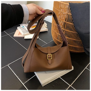 Détail d'un sac à bandoulière en cuir marron à motif litchi avec boucle en métal doré