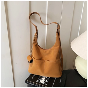 Detail view of large brown vintage tote with dual front pockets and white contrast stitching