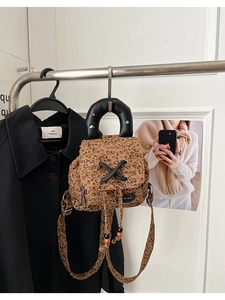 Detail of leopard print mini backpack with silver rivets and drawstring closure