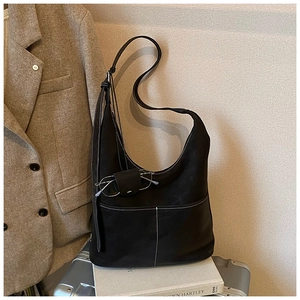 Detail of black matte leather hobo bag with contrast stitching and adjustable strap