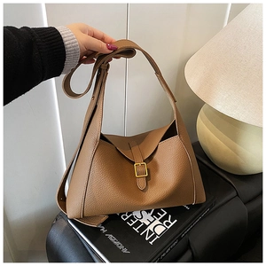 Détail du sac à bandoulière en cuir marron avec boucle dorée et sangle réglable