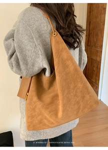 Macro shot of retro camel hobo bag with suede texture and metallic side zipper detail