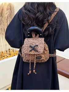 Close-up of leopard print mini backpack with rivet handle and woven strap detail