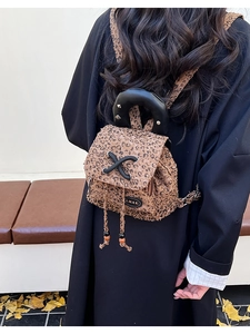 Detail of leopard print mini backpack with metal studded handle and drawstring closure