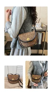Détail du sac selle à motif léopard avec fermoir tournant doré et bordure noire chic