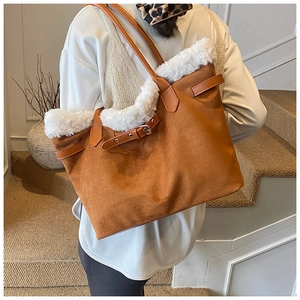 Detail of a large brown suede tote bag with plush white faux fur trim and leather straps
