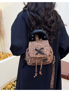 Back view of a mini leopard print backpack with rivet leather handle and drawstring closure