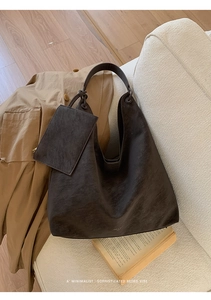 Macro shot of dark brown oversized leather tote bag and a matching small zipper pouch