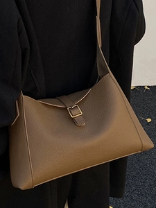 Sac hobo vintage en cuir marron avec boucle dorée et texture grainée pour le style hiver