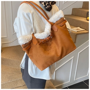 Detail of retro brown suede tote bag with white faux fur trim and adjustable leather strap