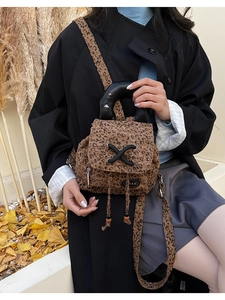 Close-up of a mini leopard print backpack with rivet handle and drawstring details