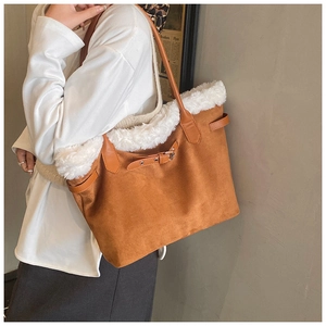 Close-up of dark brown suede tote bag featuring white faux fur trim and leather buckle