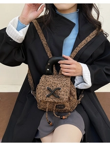 Detail of mini leopard print canvas backpack with drawstring and black top handle