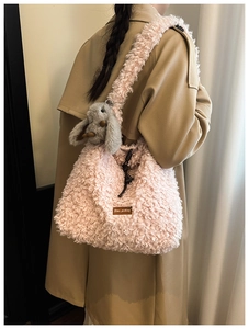 Pink plush tote bag detail with fuzzy fabric texture and cute rabbit charm pendant