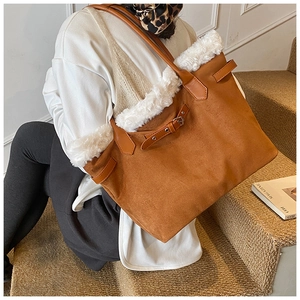 Brown tote bag with white faux shearling trim on model for autumn fashion look
