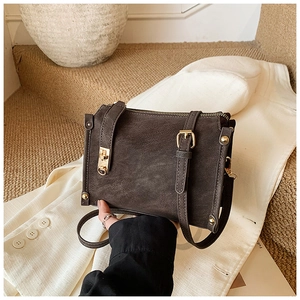 Macro shot of vintage dark brown tote bag with golden hardware and textured material