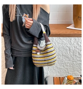 Close-up of a striped knit tote bag with a cute mushroom pendant in a cozy lifestyle setting