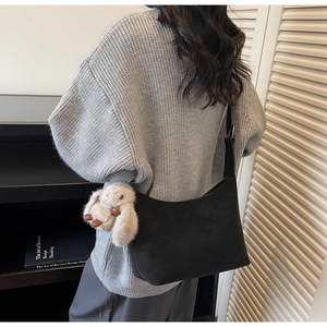 Minimalist black matte shoulder bag with cute plush bunny charm for winter casual outfit