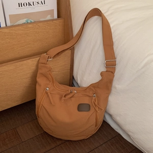 Detail of caramel canvas tote bag with adjustable strap and multiple zip pockets