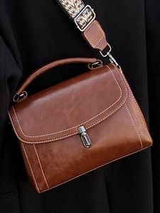 Chic caramel brown crossbody handbag with ethnic pattern strap and metal clasp