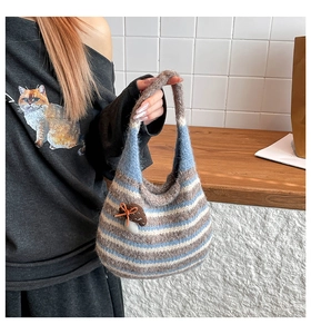 Close-up of hand-crocheted striped tote bag with a cute 3D mushroom charm and bow