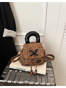 Detail of leopard print mini backpack featuring metal studs and leather handles