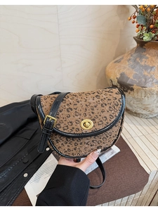 Détail du sac selle à motif léopard avec fermoir doré et finitions en cuir noir de qualité