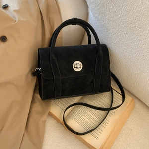 Detail of a vintage black matte crossbody bag with a silver metal twist lock closure