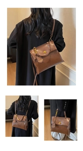 Detail of vintage brown leather backpack showing gold twist lock and handle texture