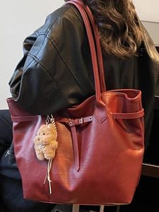 Vintage burgundy large capacity tote bag with bear pendant worn on model's shoulder