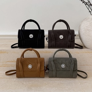 Close-up of four matte vintage handbags in earth tones with silver metal turn-lock buckles