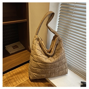 Detail view of khaki quilted tote bag showing irregular pleated texture and fabric strap
