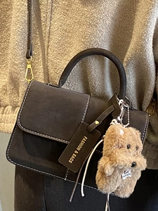 Minimalist grey frosted leather crossbody bag with white stitching and puppy charm
